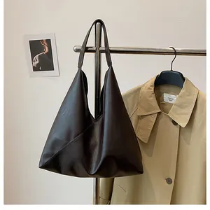Detail view of the soft dark brown leather tote bag with elegant draped triangle design