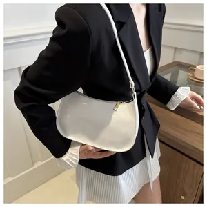 Detalle de bolso hobo de charol blanco brillante con cierre de cremallera de metal dorado
