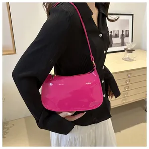 Detalle del bolso de hombro en charol fucsia con acabado brillante y cremallera dorada