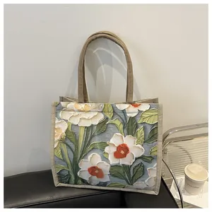 Vista detallada del patrón floral de pintura al óleo 3D en el bolso de lino natural
