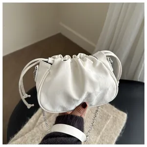 Close-up of white ruched cloud bag featuring silver chain and soft lychee texture leather