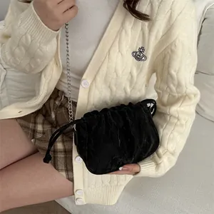 Chic black pleated cloud crossbody bag with silver chain strap shown on a model
