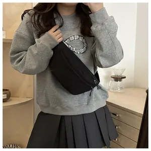 Minimalist black canvas crossbody chest bag styled with a sequin grey sweatshirt