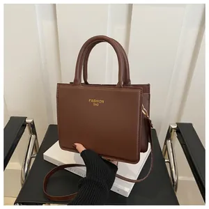Close-up of a retro brown crossbody bag with gold Fashion Bag text and handle