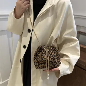 Bolso de cubo con estampado de leopardo y cordón con correa de cadena dorada para mujer.