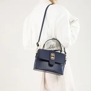 Navy blue faux leather crossbody bag with gold buckle and top handle for women