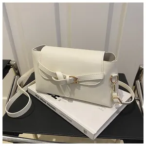 Gros plan du sac en cuir blanc texturé avec nœud de boucle de ceinture et détails dorés