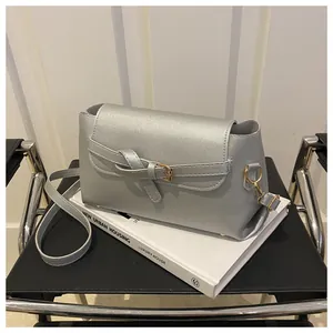 Détail du sac bandoulière argenté avec boucle à nœud et finition métallisée