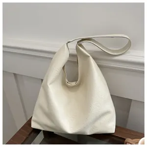 Detail der Hobo-Tasche in Cremeweiß aus Kunstleder mit weicher Faltenstruktur und Trageriemen
