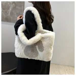 Detail of soft white faux fur tote bag featuring a grey heart pattern and plush strap