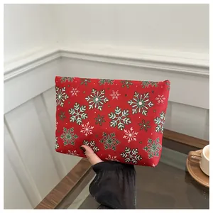 Detail of red Christmas makeup bag with festive snowflake patterns held in hand
