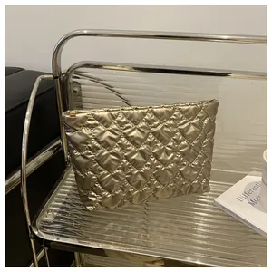 Macro detail of golden quilted heart pattern and metallic texture on luxury makeup bag