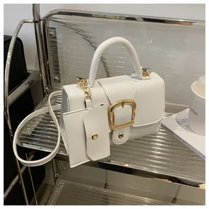 Detail van witte lederen handtas met gouden U-gesp en bijpassend mini-kaarthouder tasje