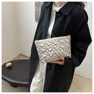 Close-up of silver quilted heart pattern vanity pouch with glossy metallic finish