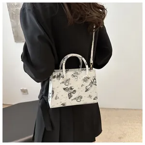 Détail du sac cabas crème avec imprimé papillon et bandoulière polyvalente pratique