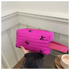 Detail der rosaroten gesteppten Kosmetiktasche mit schwarzen Schleifen-Stickereien