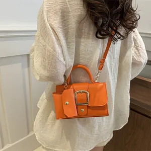 Stijlvolle oranje crossbodytas van kunstleer met gouden gesp en verstelbare riem