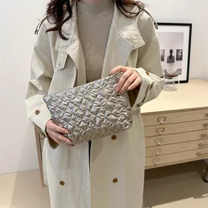 Silver quilted heart clutch bag with metallic finish shown in a stylish room setting
