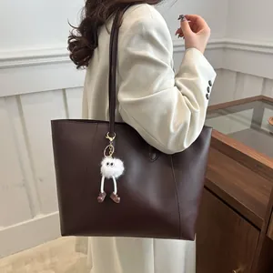 Retro large coffee tote bag for women with plush monster charm in a minimalist interior