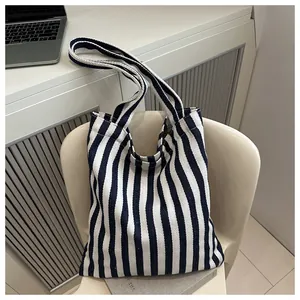 Detail of blue and white vertical striped canvas tote bag on a minimalist chair