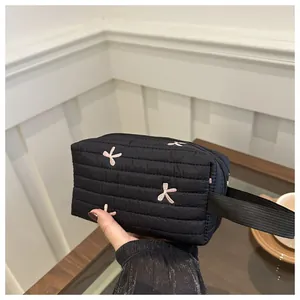 Detailansicht der schwarzen gesteppten Kosmetiktasche mit eleganter rosa Schleifenstickerei