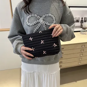Quilted black makeup bag with pink bow embroidery and large capacity for travel storage