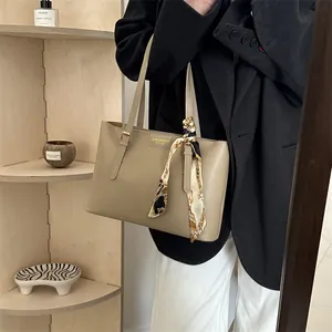 Retro khaki leather tote bag with decorative silk scarf shown in a modern urban setting