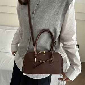 Vintage dark brown leather bowling bag for women featuring dual handles and shoulder strap