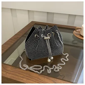 Close-up of rhinestone bucket bag with drawstring closure and decorative pearl accents