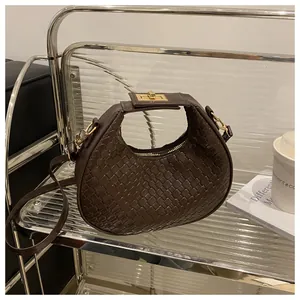 Détail du sac hobo croissant tressé marron foncé avec ferrures dorées et zip