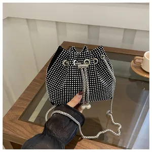 Close-up of black PU bucket bag featuring sparkling rhinestones and pearl chain drawstring