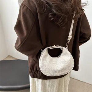 Sac à main en bandoulière beige à motif crocodile avec des finitions dorées