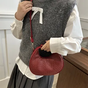Sac à main croissant tressé rouge avec bandoulière réglable au style minimaliste