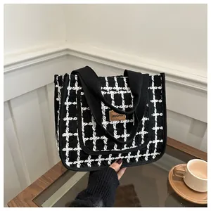 Détail du sac cabas à carreaux noir et blanc avec logo en cuir et large bandoulière