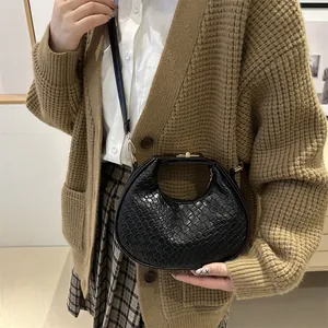 Sac à bandoulière croissant noir tissé avec fermoir tournant doré élégant