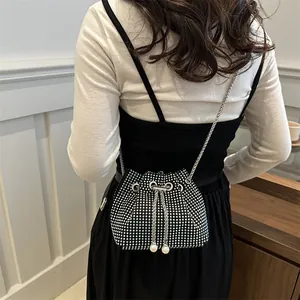 Sparkly rhinestone bucket bag with silver chain strap and pearl drawstring details