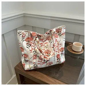 Detail of vintage floral canvas tote bag with red flowers on a wooden table with coffee