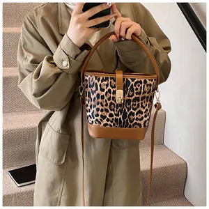 Detail der Leopard-Eimertasche mit goldenem Drehverschluss und braunem Leder