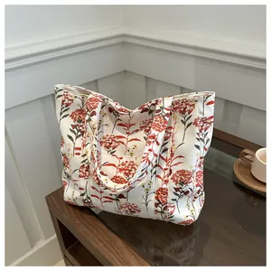 Close-up of floral canvas tote bag featuring red flowers and a practical front pocket