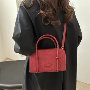Red corduroy handbag for women with leather trim and adjustable crossbody strap