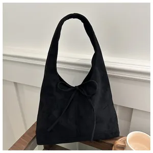 Detail of a black bow-tie tote bag with a soft matte finish and stylish hobo design
