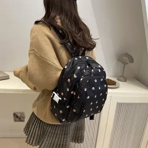 Japanese style black mini backpack with pink floral prints and side buckle details