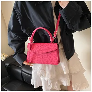 Detail of pink embossed clover patterns on a stylish PU leather crossbody handbag