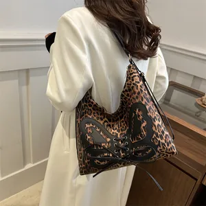 Sac hobo à motif léopard avec applique papillon noire et design à lacets croisés