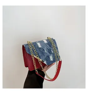 Detail of vintage blue denim patchwork and red leather trim on the chain crossbody bag