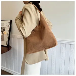 Macro detail of caramel brown suede tote bag featuring premium matte texture and stitching