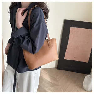 Caramel tote bag with contrast white stitching shown worn by model in a minimal setting