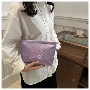 Detail of lavender satin tote with pink butterfly embroidery and smooth silk texture