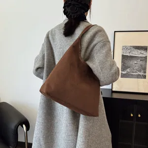 Brown minimalist suede tote bag styled over the shoulder for high-end casual wear