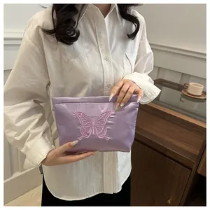 Detail of lavender satin clutch with pink butterfly embroidery for elegant storage
